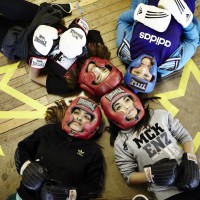 Performers from the site-specific theatre piece No Guts No Heart No Glory, about female muslim boxers, in boxing gear lying on the floor.
