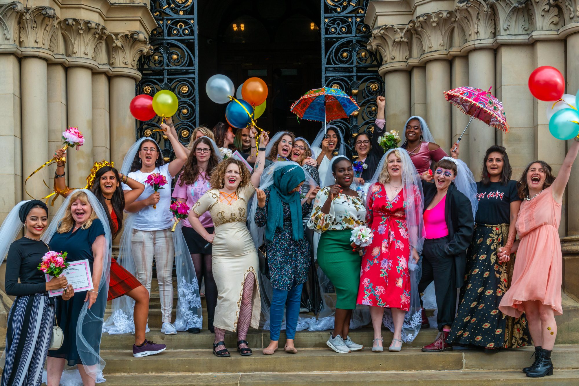 A celebratory photograph of colourful brides from the Wedding Of The Year, a socially engaged piece where women married themselves.