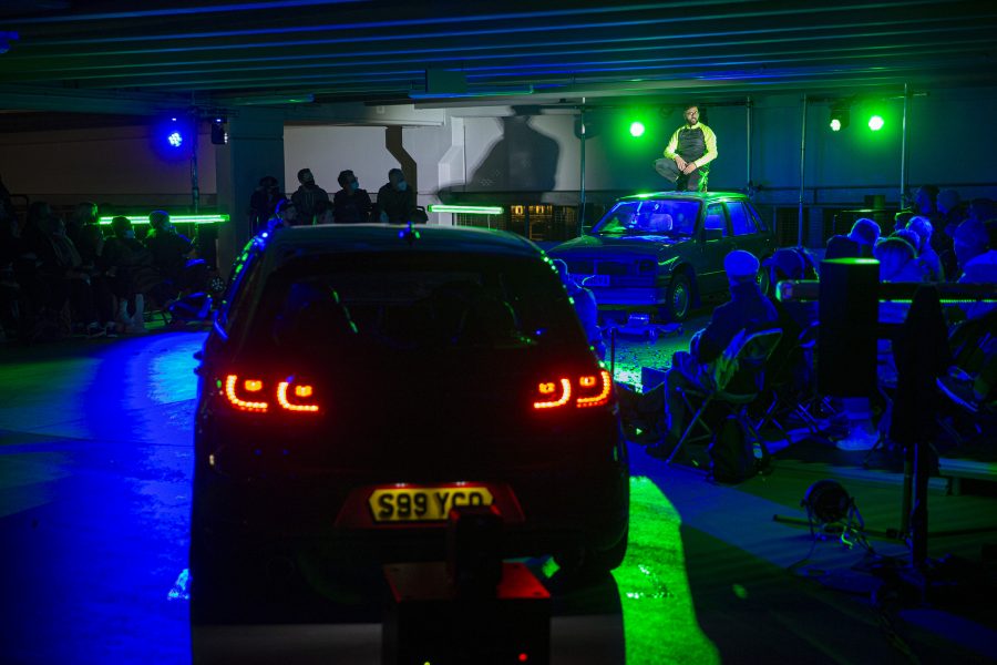 A car is in a neon lit car park