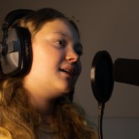 young girl wearing headphones and mic