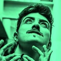 Photographic portrait in green and black of drag king Len Blanco