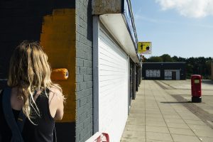 Helen Bur begins to paint the wall orange