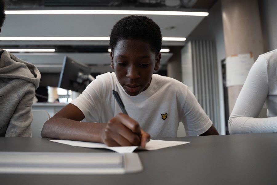 A young man works independently at a table.