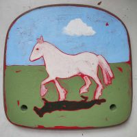 Large white horse painted by Crab & Bee as part of their Matter of Britain book. It looks as though it has been painted on metal, and is cantering across grass with a blue sky above.