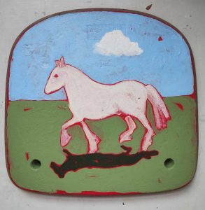 Large white horse painted by Crab & Bee as part of their Matter of Britain book. It looks as though it has been painted on metal, and is cantering across grass with a blue sky above.