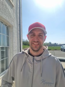 Man with baseball cap smiling at the camera at Llanrumney Hall.
