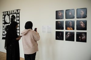 Audience member photographing photography on the wall.
