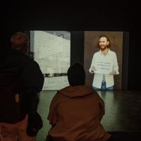Audience members viewing art piece