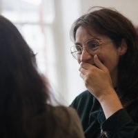 Audience members smiling and speaking to each other at launch event.