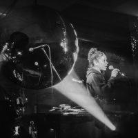 Jassen and Bianca sing in front of a huge Glitter Ball 