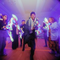 A group of young people performing against a purple background